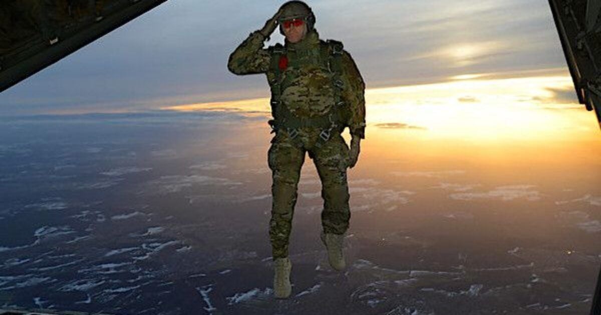 A U.S. soldier assigned to 1st Battalion, 10th Special Forces Group (Airborne) salutes his fellow soldiers while jumping out of a C-130 Hercules aircraft over a drop zone in Germany, Feb. 24, 2015. (U.S. Army photo by Visual Information Specialist Jason Johnston)